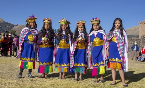 Sechs junge Frauen posieren in traditioneller Kleidung für ein Foto.